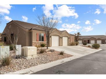 Charming single-story home featuring attached garages, desert landscaping, and a tile roof at 344 Tuscany Cir, Mesquite, NV 89027