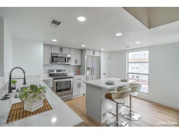 Bright kitchen features stainless steel appliances and a center island with bar seating at 3790 Shirebrook Dr # 167, Las Vegas, NV 89115