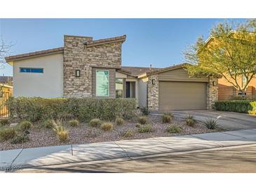 Charming single-story home featuring stone accents, desert landscaping, and an attached two-car garage at 9765 Skye Star Ave, Las Vegas, NV 89166