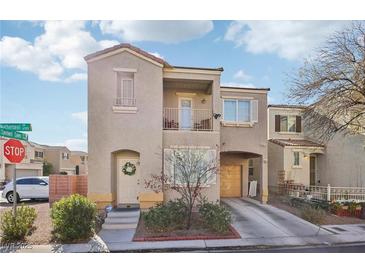 Charming two-story home featuring a front balcony, covered parking, and a welcoming front entrance with desert landscaping at 6527 Netherseal Ave, Las Vegas, NV 89139