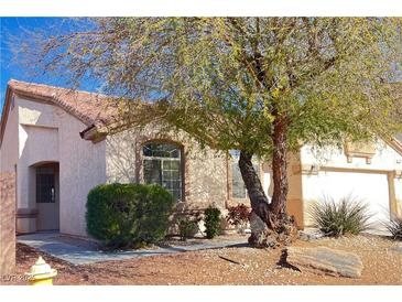 Charming single-story home featuring a well-maintained yard and mature tree for added curb appeal at 7515 Splashing Rock Dr, Las Vegas, NV 89131