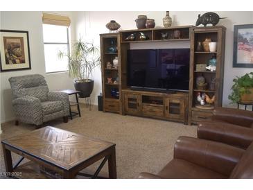 Cozy living room featuring a decorative entertainment center, comfortable seating, and ample natural light at 7515 Splashing Rock Dr, Las Vegas, NV 89131