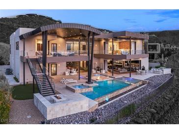 Contemporary home featuring a luxurious backyard with a pool, spa, and fire pit lounge area at 11 Rockstream Dr, Henderson, NV 89012