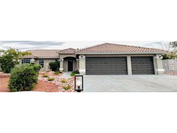 Charming single-story home featuring a tile roof, desert landscaping, and a three-car garage at 308 Cannes St, Henderson, NV 89015