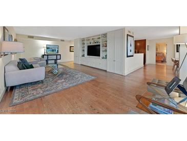Spacious living room featuring hardwood floors, custom built-ins, and an open layout at 3111 Bel Air Dr # 7D, Las Vegas, NV 89109