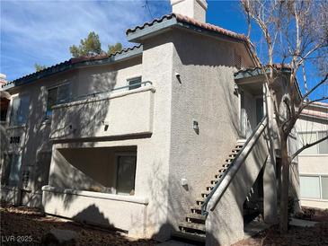 Two-story condo with stucco siding, staircase, and small balcony at 3119 Key Largo Dr # 204, Las Vegas, NV 89120