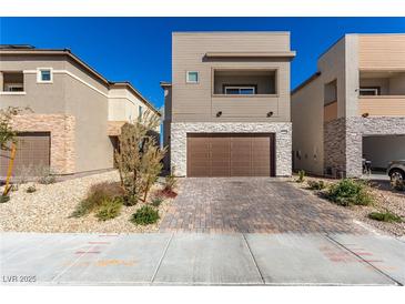 Modern two-story home featuring a stone facade, a two-car garage, and a landscaped front yard at 9714 Harper Edge St, Las Vegas, NV 89143