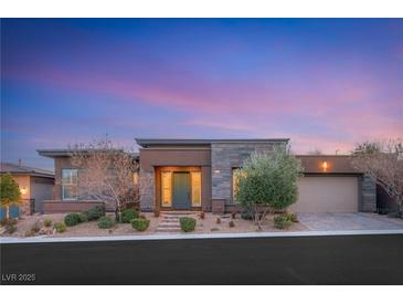 Beautiful single-story home featuring a low-maintenance front yard and a modern color palette at dusk at 10179 Emerald Sunset Ct, Las Vegas, NV 89148