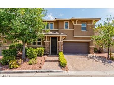 Charming two-story home featuring a landscaped yard, brick accents, and a welcoming entryway at 10313 Aragon Crown Rd, Las Vegas, NV 89135