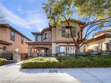 Charming two-story home with stone accents, manicured landscaping, and a welcoming front porch at 7719 Windy Meadow Ave, Las Vegas, NV 89178