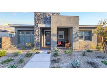 Charming single-story home with a stone accent wall and manicured desert landscaping at 905 Belleforte Ln, Las Vegas, NV 89138