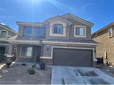 Two-story home with gray stucco, stone accents, desert landscaping, and a two-car garage at , Las Vegas, NV 89148