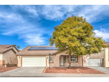 Charming single-story home with a well-manicured yard, solar panels, and a two-car garage at 904 Melic Way, North Las Vegas, NV 89032