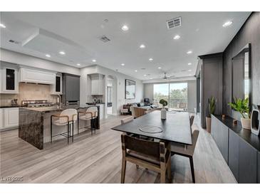 Open-concept living area featuring a kitchen with an island, dining area, and comfortable seating with a view at 9101 Alta Dr # 11, Las Vegas, NV 89145
