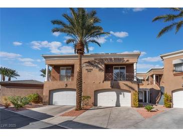 Inviting townhouse complex with a desert landscape and attached two-car garages at 1405 San Juan Hills Dr # 104, Las Vegas, NV 89134
