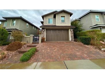 Two-story home featuring a brick driveway, attached garage, and well-maintained landscaping at 343 Cadence Vista Dr, Henderson, NV 89011