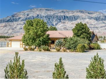 Charming single-story home features well-kept landscaping and a spacious gravel yard with mountain views at 5090 N David St, Pahrump, NV 89060