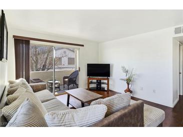 Bright living room features sliding glass doors to a balcony and comfortable seating area at 5092 Mandalay Springs Dr # 201, Las Vegas, NV 89120