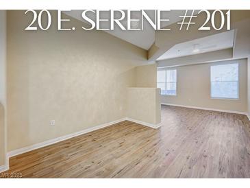 Bright living room with hardwood floors and natural light from large windows overlooking the community at 20 Serene Ave # 201, Las Vegas, NV 89123