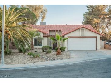 Charming single-story home with a desert landscape, two-car garage, and mature palm trees at 2823 Landau Ct, Henderson, NV 89074