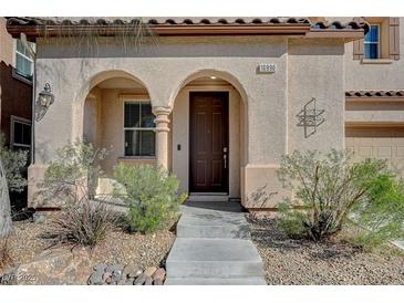 Charming front entrance featuring a covered porch with archways and a well-maintained landscaped yard at 10990 Mountain Willow St, Las Vegas, NV 89179