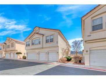 Charming townhomes featuring three garage spaces and neutral color scheme against a beautiful bright blue sky at 1631 Lefty Garcia Way, Henderson, NV 89002