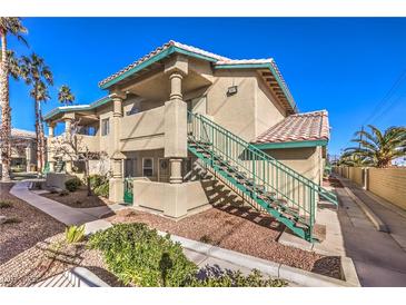 Charming two-story condo with landscaped yard, exterior stairs, and neutral stucco at 328 S Buffalo Dr # 101, Las Vegas, NV 89145