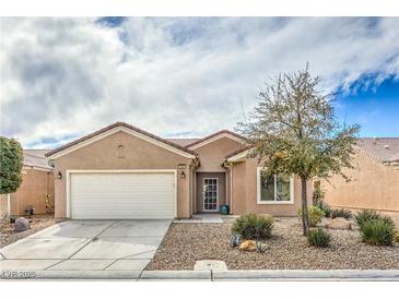 Charming single-story home featuring desert landscaping, a two-car garage, and a tile roof at 3305 Fernbird Ln, North Las Vegas, NV 89084