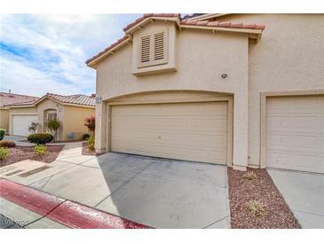 Exterior view of a two-car garage with beige doors and a red tile roof on a sunny day at 3425 Conan St # 103, Las Vegas, NV 89129