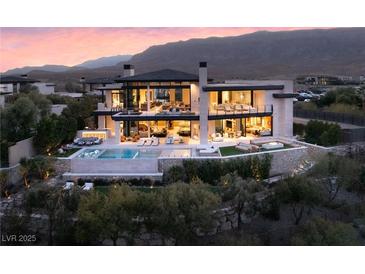 Stunning two-story home featuring an in-ground pool, luxurious outdoor seating, and a captivating mountain view at 4918 Summit Overlook Dr, Las Vegas, NV 89135