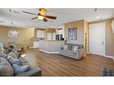 Open-concept living room featuring modern ceiling fan, hardwood floors and contemporary decor at 6121 Sinatra Sands Ct, Las Vegas, NV 89130