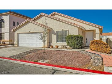Single story home with neutral stucco, tile roof, rock landscaping, and a two car garage at 8728 Honey Vine Ave, Las Vegas, NV 89143