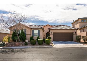 Charming single-story home featuring a well-manicured yard with mature trees and a two-car garage at 10417 Artful Stone Ave, Las Vegas, NV 89149