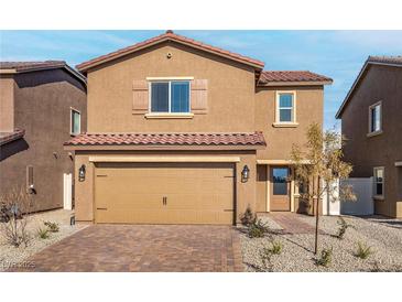 Inviting two-story home boasts a tile roof, neutral stucco, a two car garage, and desert landscaping at 1705 Desert Path Ave, North Las Vegas, NV 89032