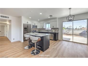 Bright, modern kitchen with stainless steel appliances, island with seating and sliding glass doors to backyard at 2605 Amarillo St, Las Vegas, NV 89102