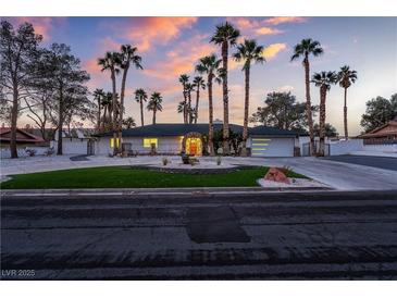 Charming single-story home with manicured lawn, mature palm trees, and circular driveway, set against a colorful dusk sky at 3467 W Mardon Ave, Las Vegas, NV 89139