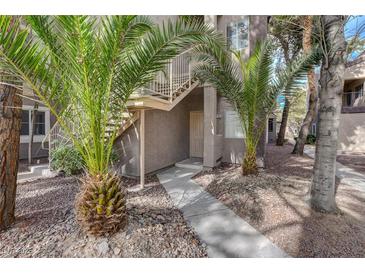 Charming condo entrance with well-maintained walkway and lush palm trees at 5250 S Rainbow Blvd # 2165, Las Vegas, NV 89118