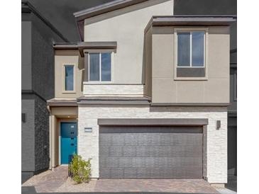Beautiful two-story home featuring stone accents, a front-entry garage, and a pop of color from the turquoise front door at 11940 Vector Ray Ave, Las Vegas, NV 89138