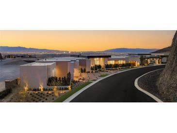 Contemporary home with a flat roof, showcasing a modern architectural design against a scenic mountain backdrop at dusk at 591 Cityview Ridge Dr, Henderson, NV 89012