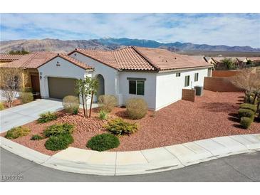 Inviting single-story home featuring desert landscaping, a neutral color palette, and a mountain view at 4571 S Via Roma Dr, Pahrump, NV 89061