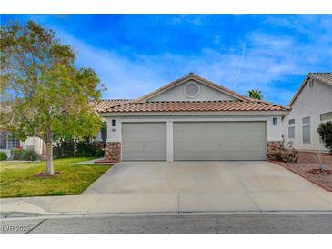 Charming home featuring a spacious two-car garage with stone accents and a well-maintained front yard at 1107 Cloudy Day Dr, Henderson, NV 89074
