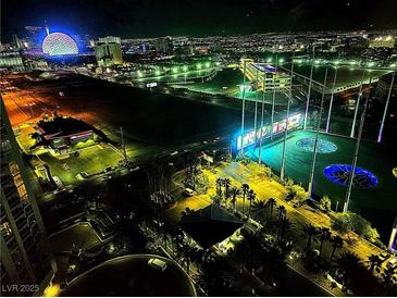 Brightly lit nighttime aerial view of a Topgolf facility with the Las Vegas strip in the background at 135 E Harmon Ave # 2120, Las Vegas, NV 89109
