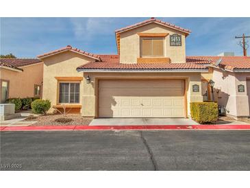 Charming townhome with a two-car garage, manicured bushes, and a terracotta tile roof at 1453 Blisworth Ct # 102, Las Vegas, NV 89102