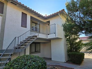 Two-story condo exterior showcasing stairs and metal railings with stucco walls and a red tile roof at 6743 W Charleston Blvd # 4, Las Vegas, NV 89146