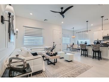 Bright, open-concept living room with sleek white sectional and modern decor at 795 Sunny Sagebrush St, Henderson, NV 89011