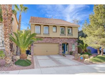 Charming two-story home with desert landscaping, paver driveway, and an attached garage and walkway at 8383 Bartholomew Park Ct, Las Vegas, NV 89139