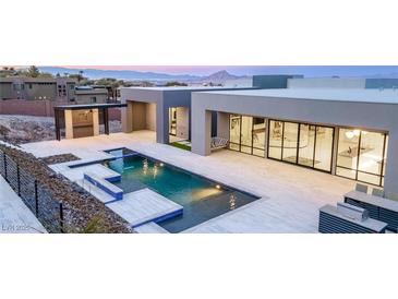 A luxury home featuring an inviting pool with inset spa and sundeck, and a patio that is perfect for entertaining at 1455 Macdonald Ranch Dr, Henderson, NV 89012