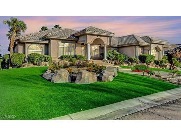 Beautiful exterior view of a house with a well-manicured lawn and rock features, showcasing its curb appeal at 1700 Brock Ct, Las Vegas, NV 89117