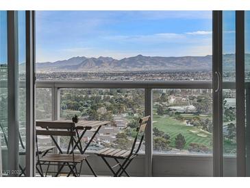 A stunning balcony view features outdoor seating, verdant trees, a golf course and mountains in the distance at 322 Karen Ave # 2206, Las Vegas, NV 89109