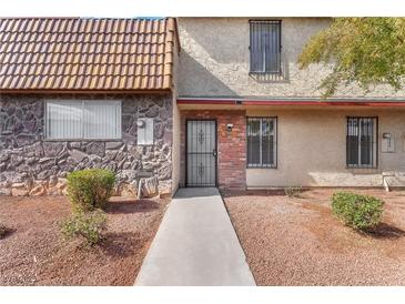 Inviting front entrance with stone and brick accents, leading to a secure gated front door at 3946 Torsby Pl, Las Vegas, NV 89119